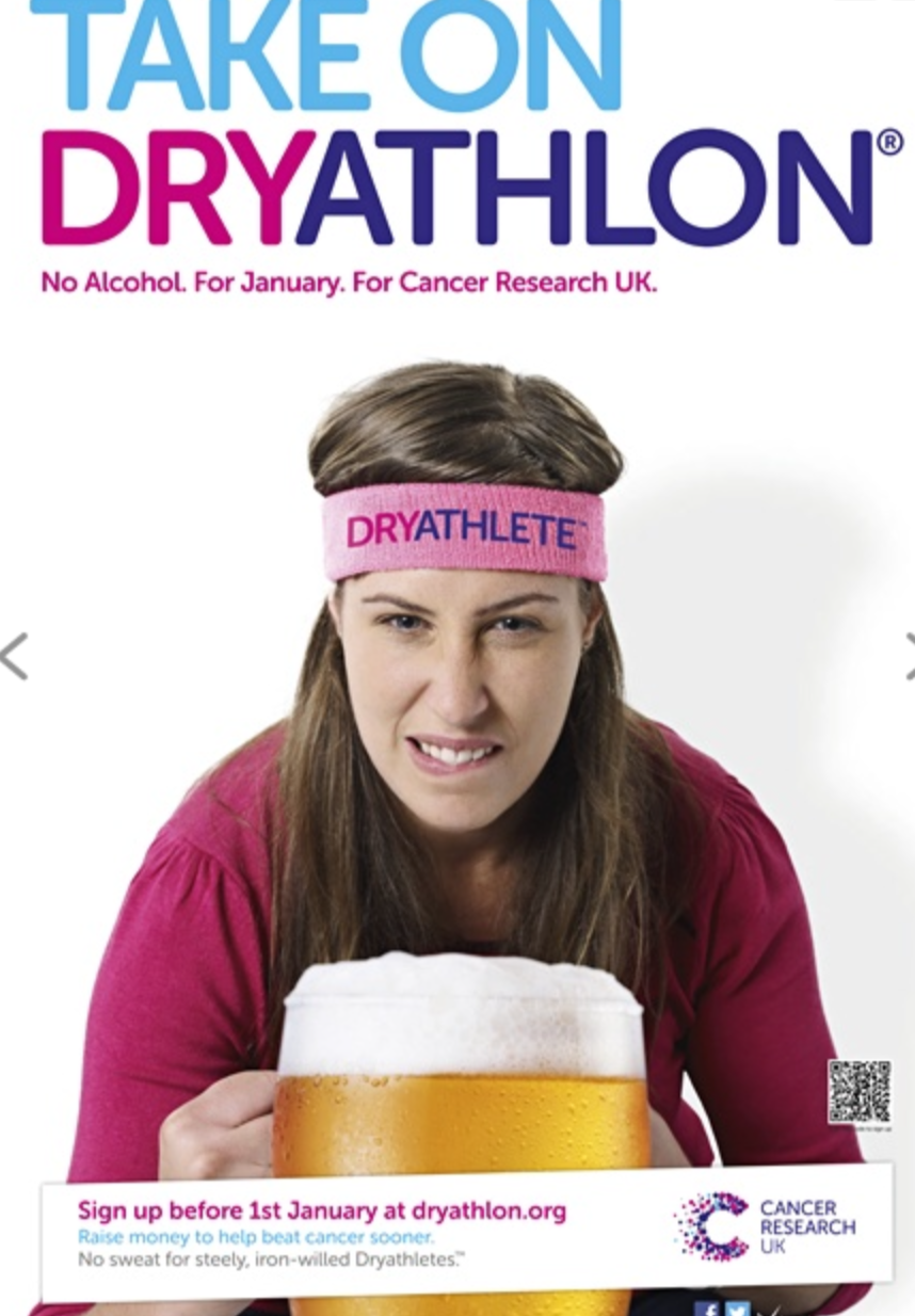 A woman with a headband that says 'DRYATHLETE' holding a large glass of beer, promoting Dryathlon for cancer research UK.