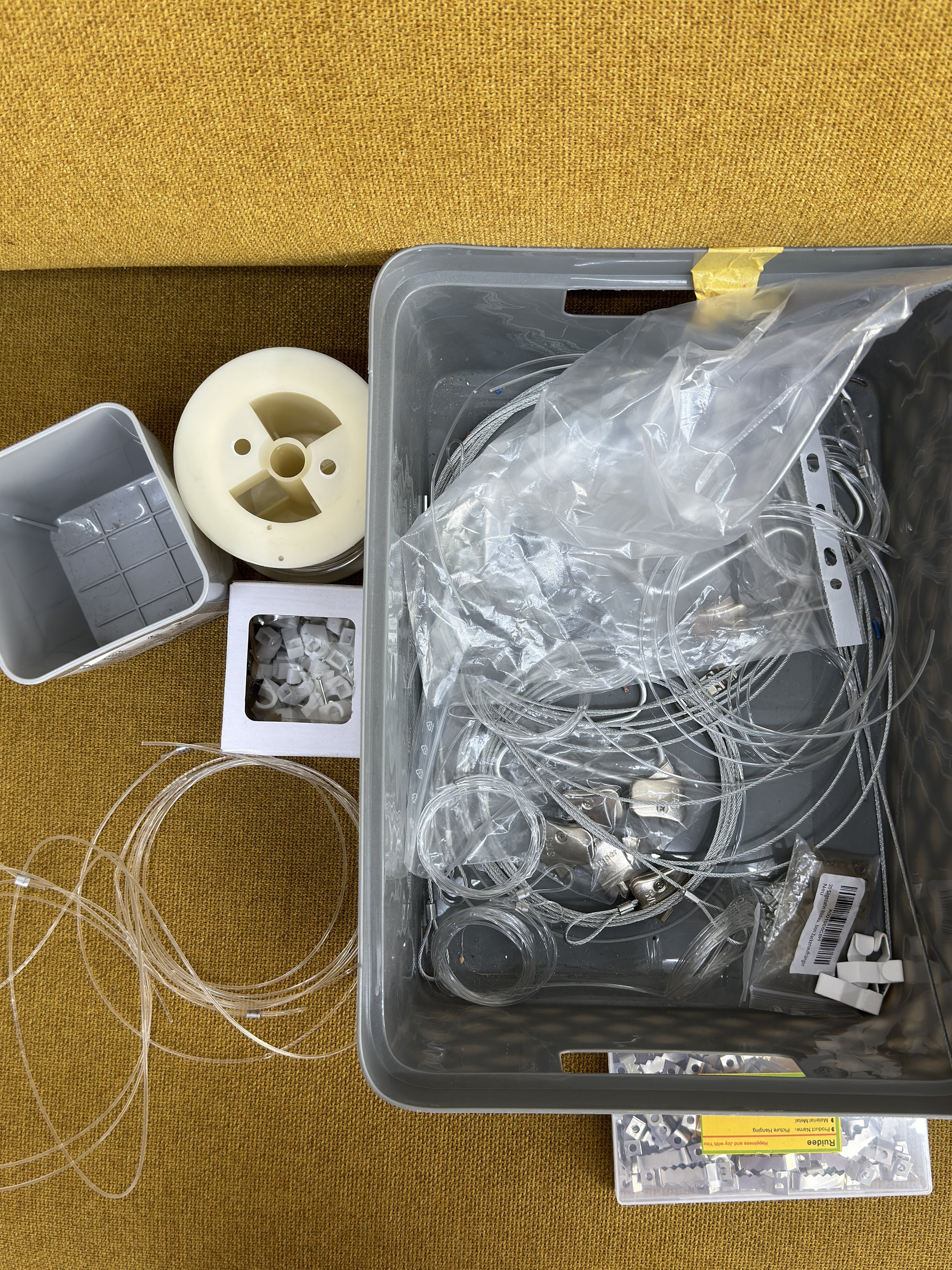 Kunststoffteile, Kabel, Boxen und Zubehör für elektrische oder technische Installation auf einem orangefarbenen Stoffuntergrund