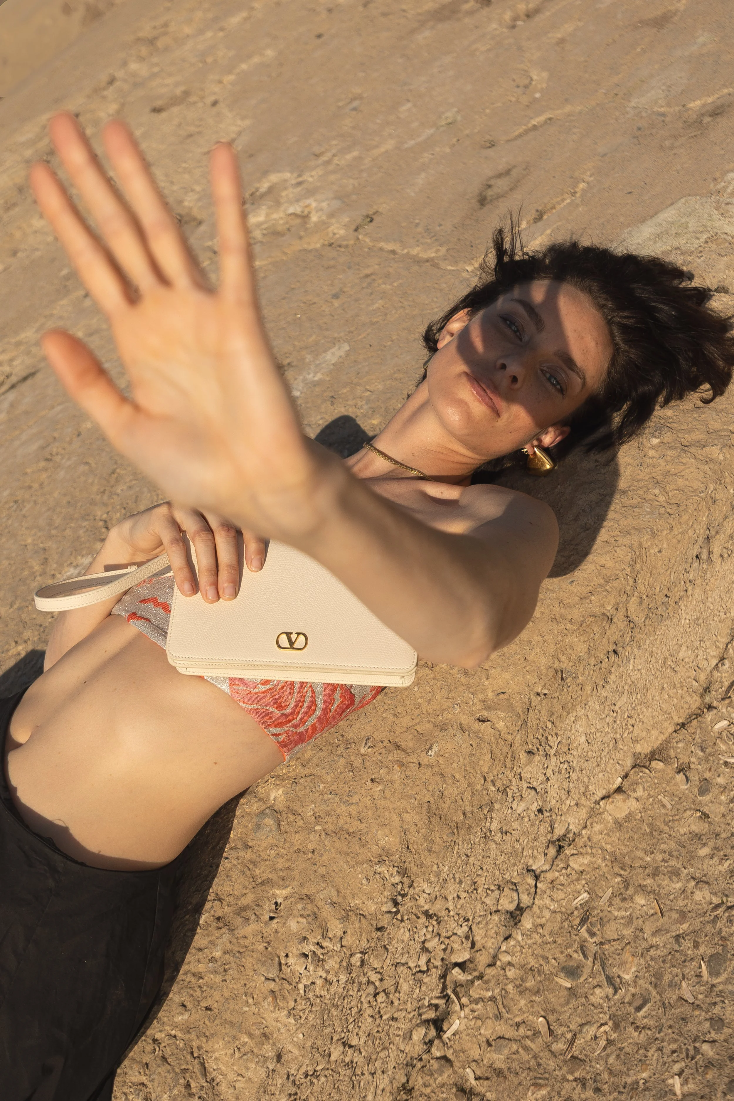 Frau liegt auf dem Boden mit ausgestreckter Hand, Sonnenlicht, Felsen, modelliert