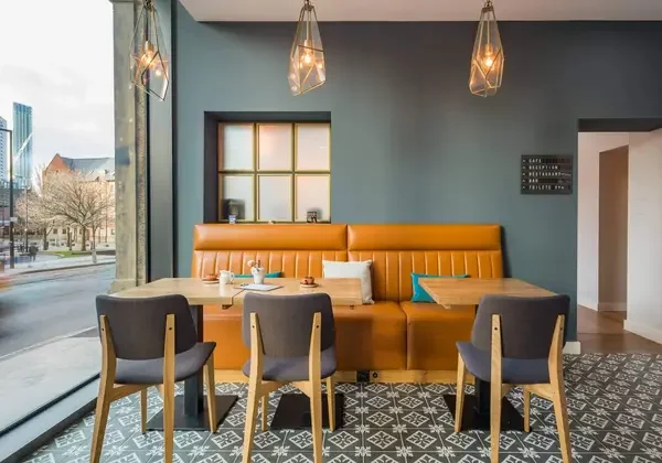 Bespoke banquette seating booth with tan leather upholstery in a restaurant, made by Shape Supply Interiors
