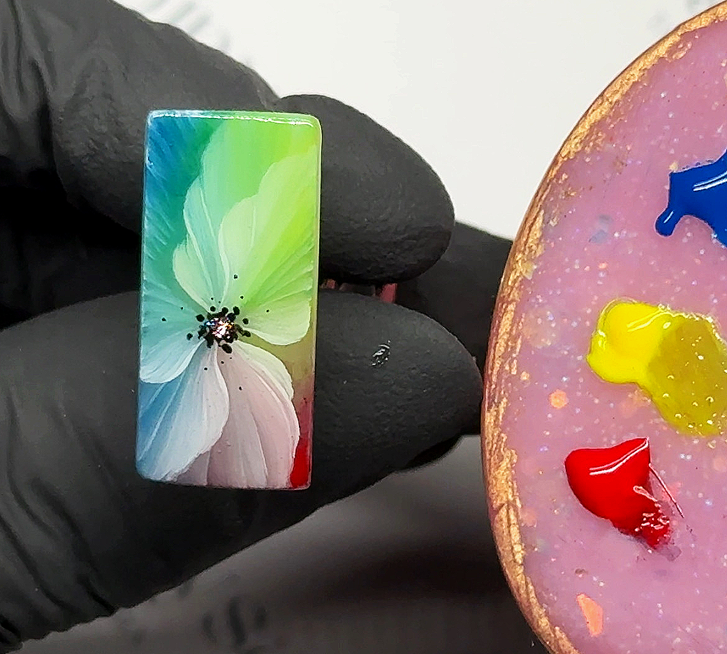 Diseño de uñas flor camaleón artística realizado sobre superficie cuadrada tipo práctica. Combinación de colores verde fluorescente, azul y detalles en blanco utilizando técnica one stroke y gel painting altamente pigmentado para lograr profundidad, 