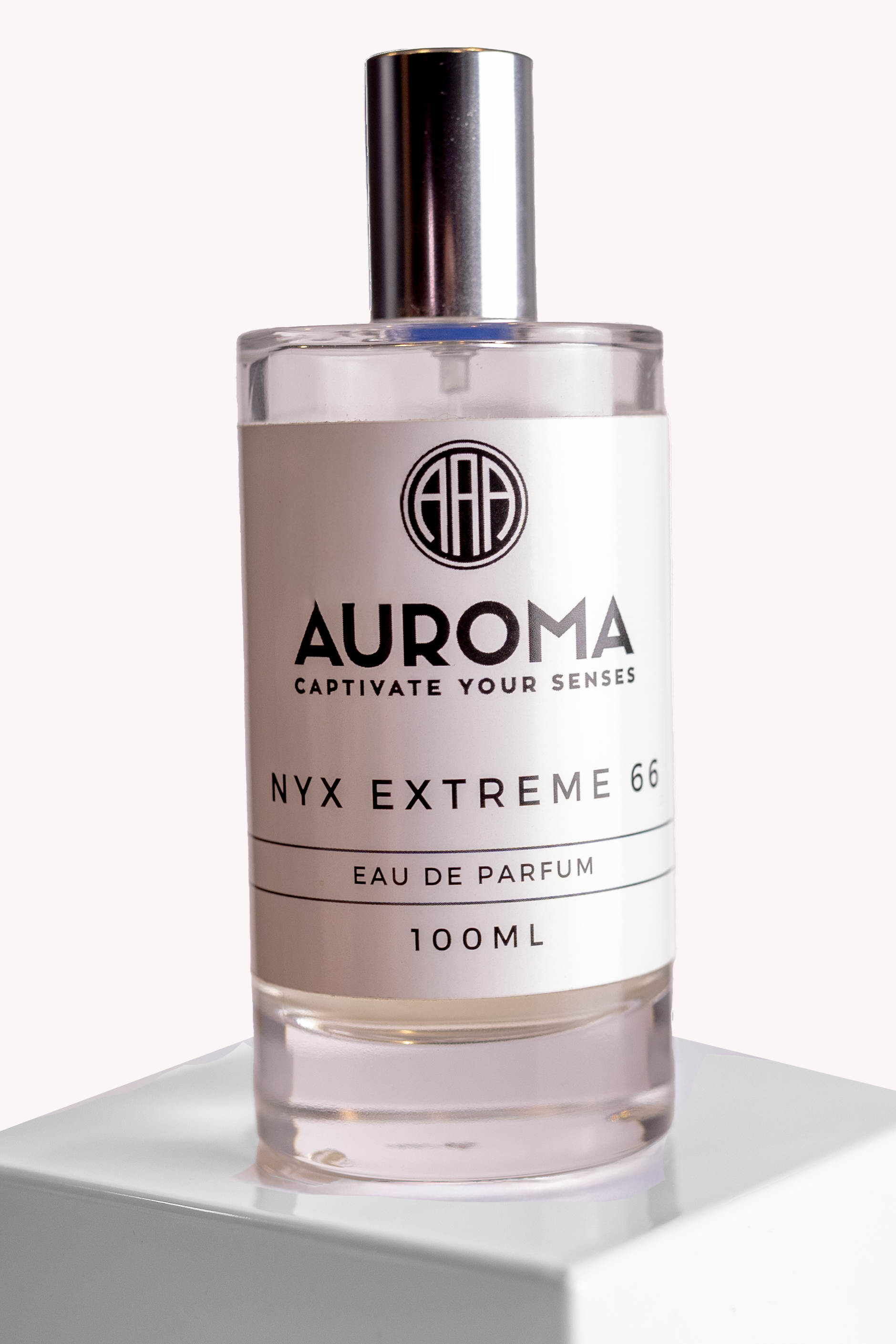 A clear glass perfume bottle with a silver cap, labeled AUROMA NYX EXTREME 66 Eau de Parfum, 100ml, placed on a white surface against a white background.