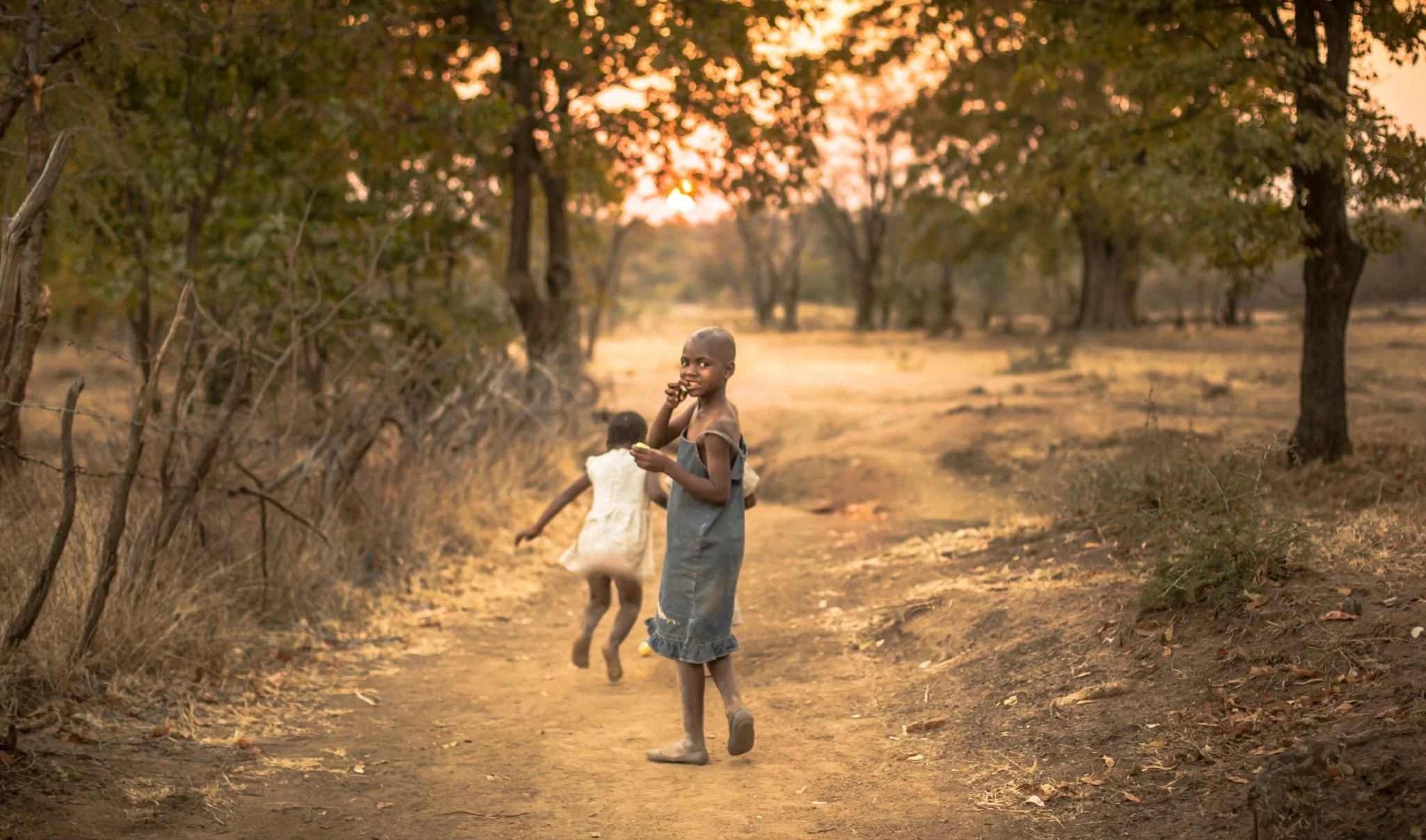 Two children playing in very rural African village with no roads or buildings