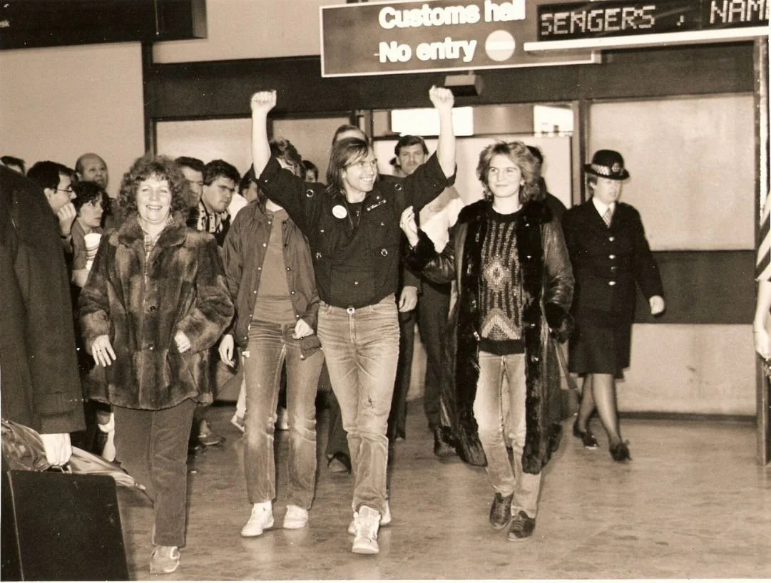 Valeri Barinov celebrating as he enters Heathrow arrivals gate after being released from Russia