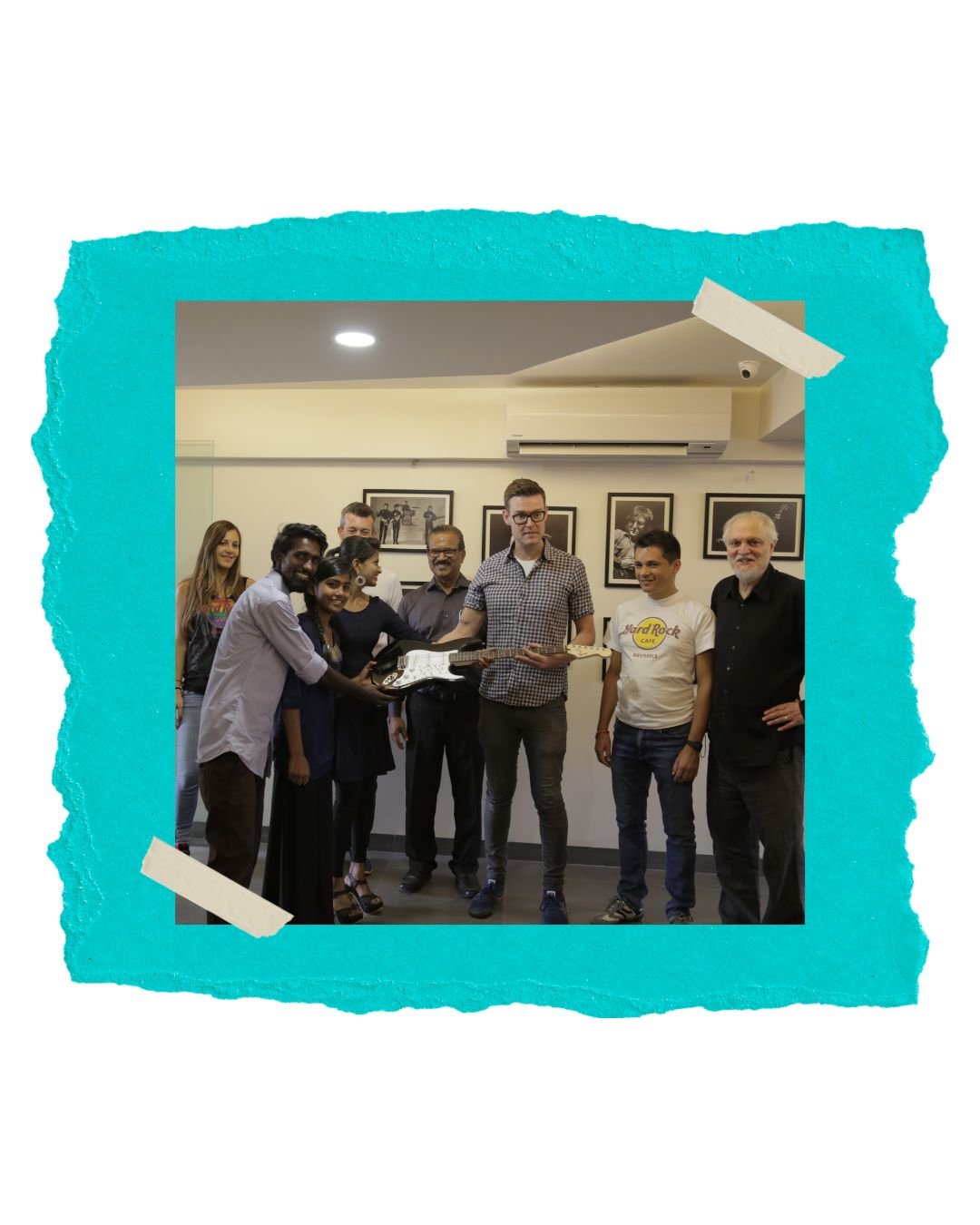 Marc Carey handing over a guitar at the music school launch