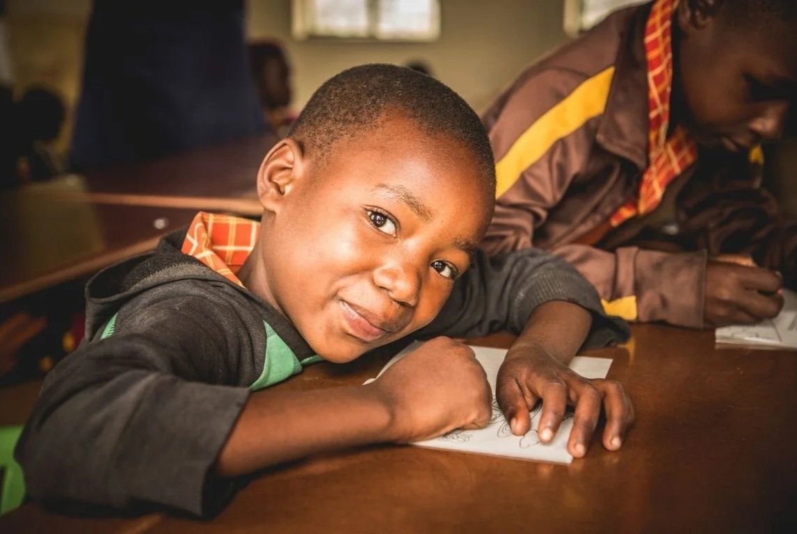 Student at Jessie's House Academy smiling as she works
