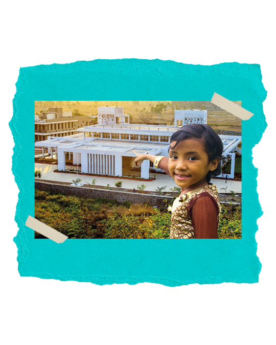 Young child pointing towards an aerial view of the new Jubilee Homes campus