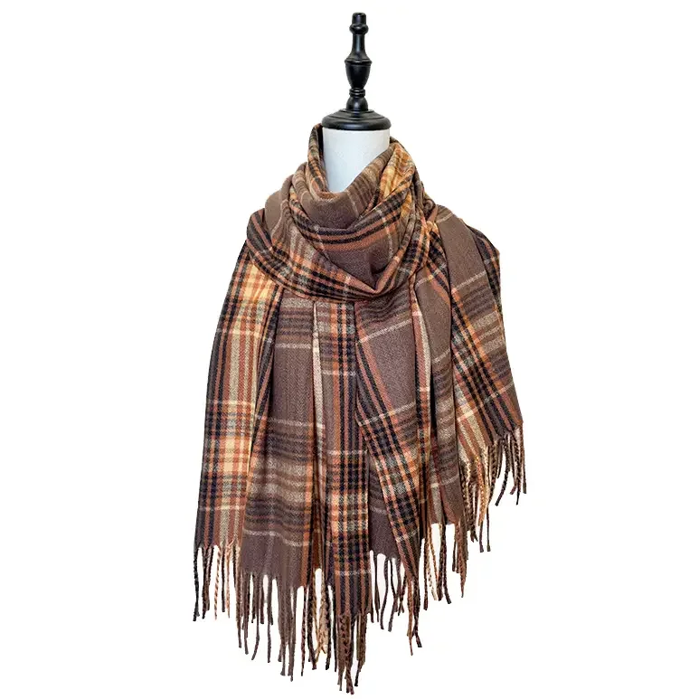 A plaid scarf with shades of brown, orange, and black draped over a mannequin bust.