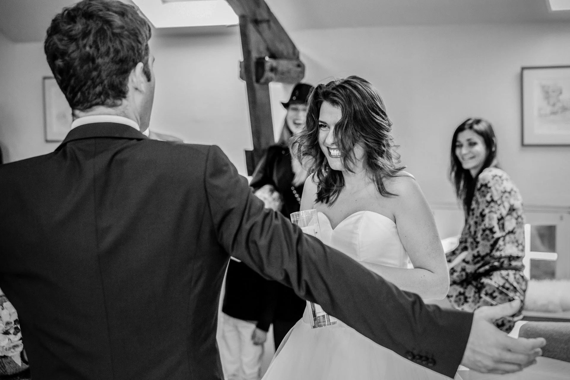 Une femme en robe de mariée souriante et joyeuse lors d'une cérémonie civile, entourée de ses proches.