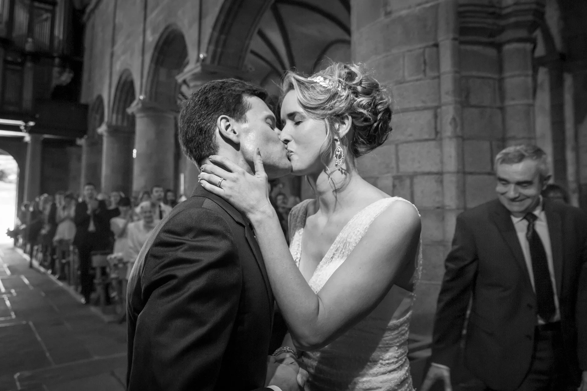 Couple de mariés s'embrassant lors de la cérémonie religieuse de mariage à Granville