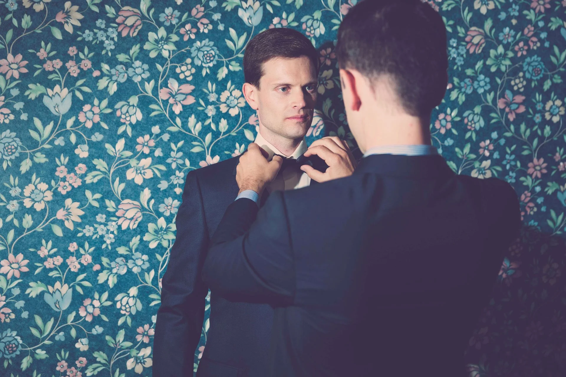 Préparatifs du marié en costume bleu accompagné de son témoin de mariage