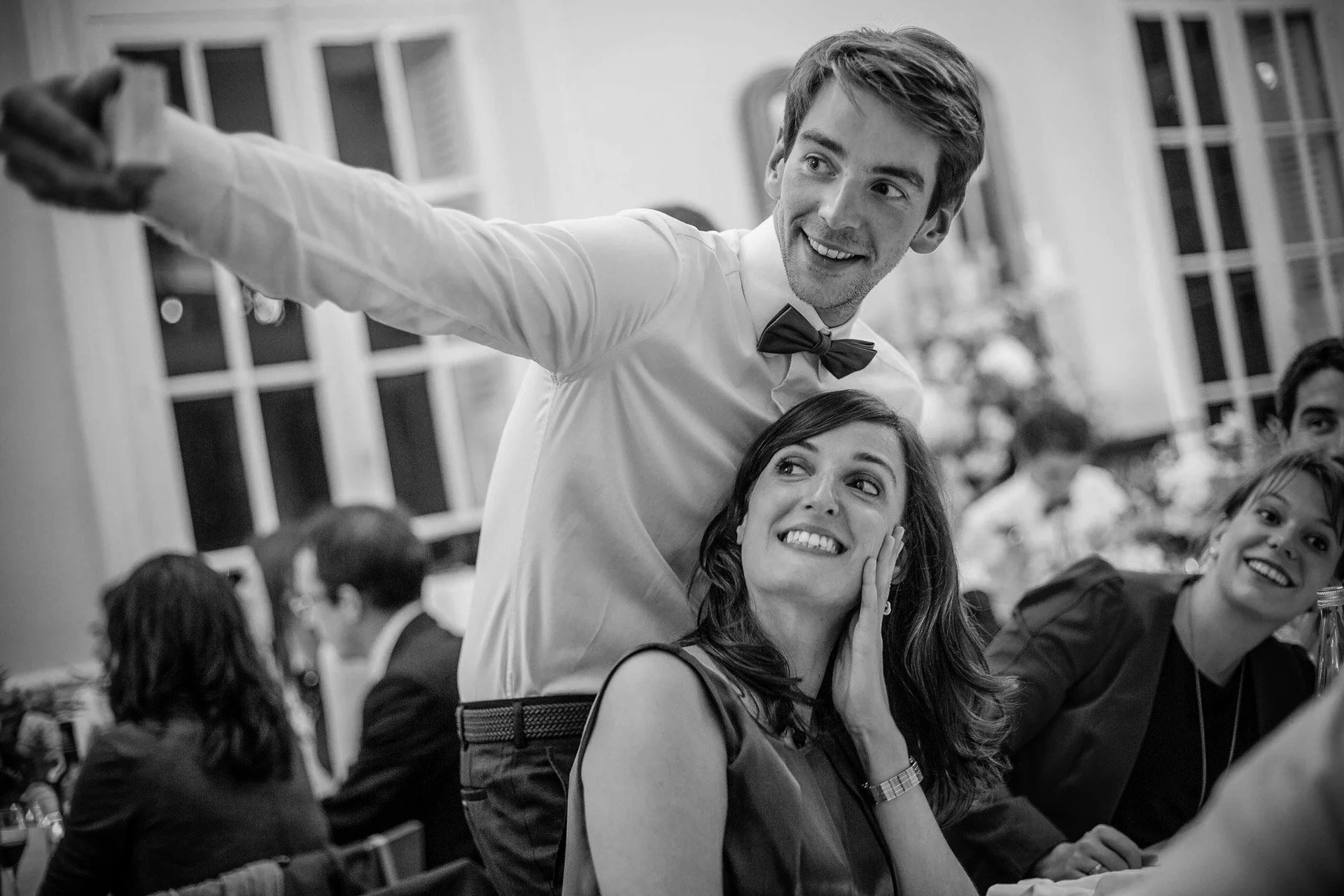 Un homme fait un selfie avec ses amis lors d'une réception de mariage.