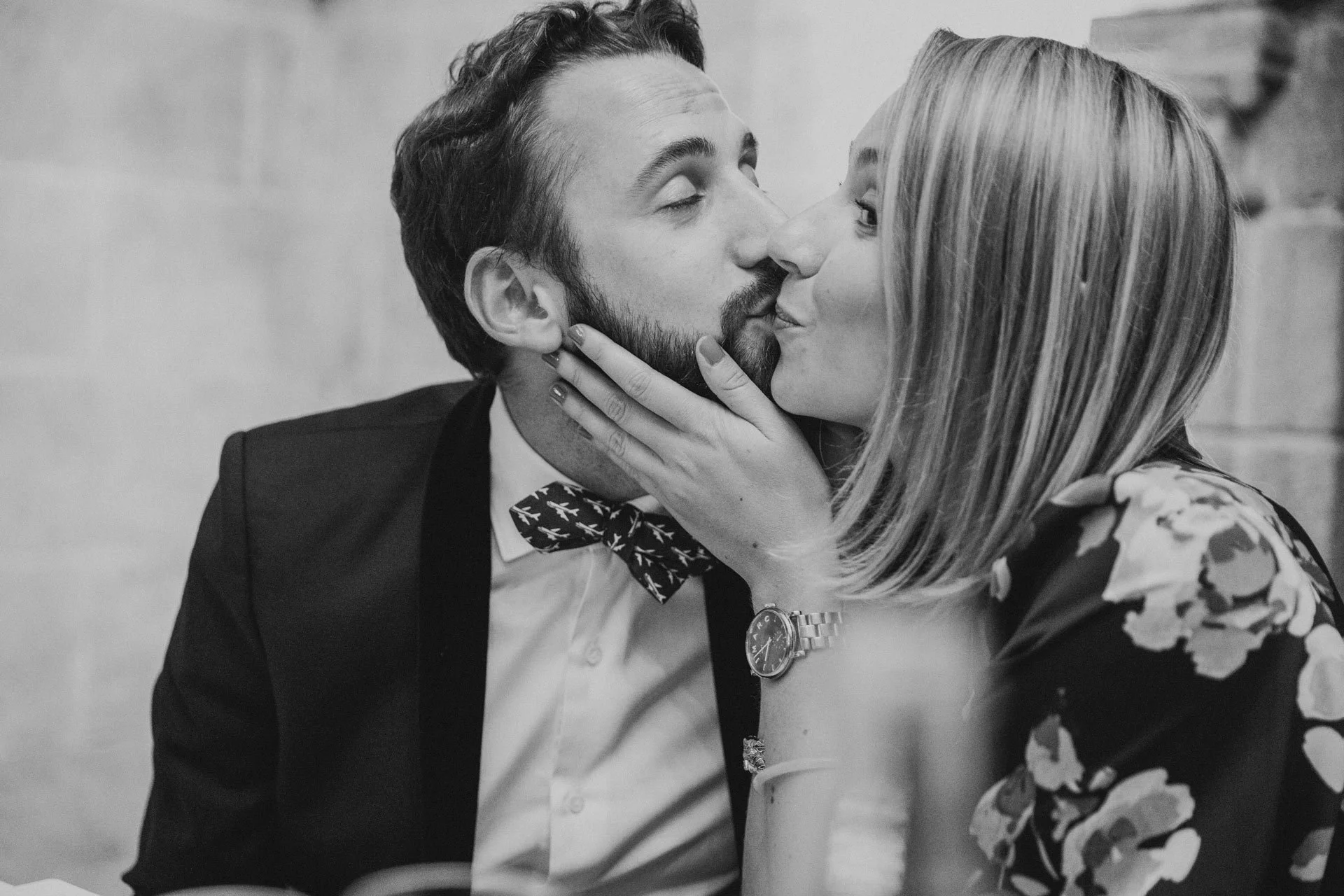Un homme et une femme s'embrassent tendrement, lors d'un diner de mariage.