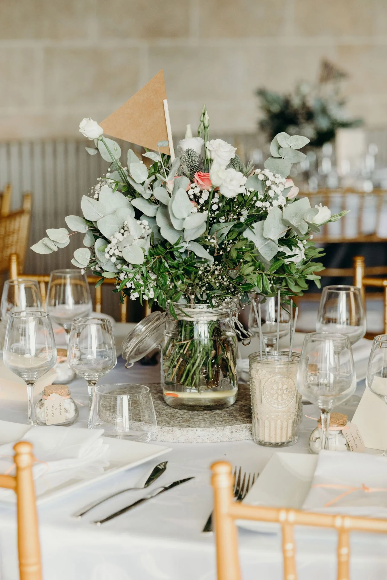 Photographe de reportage mariage, centre de table floral avec bouquet de fleurs blanches et vertes