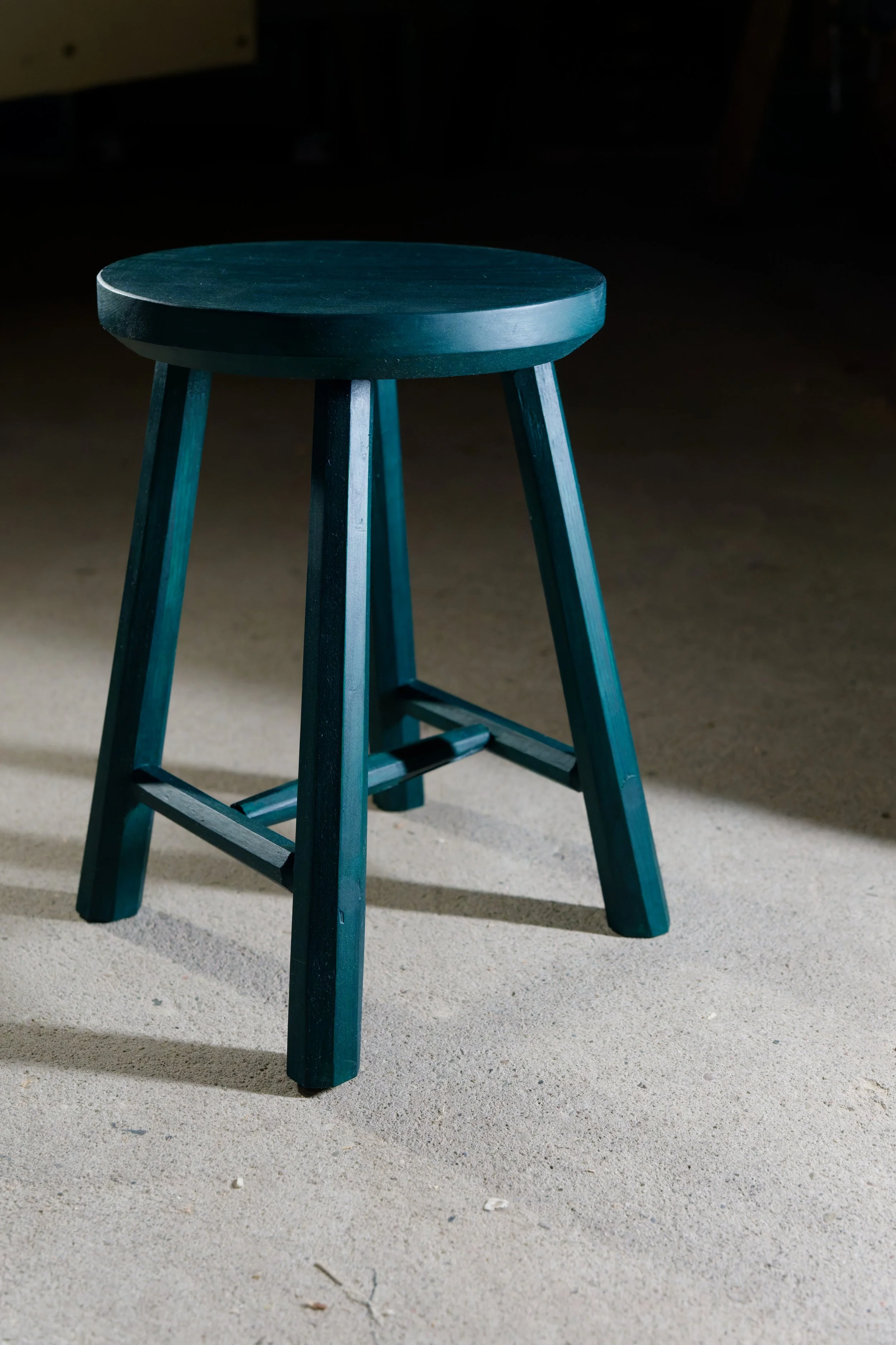 Grüner Hocker, vor grauem hintergrund