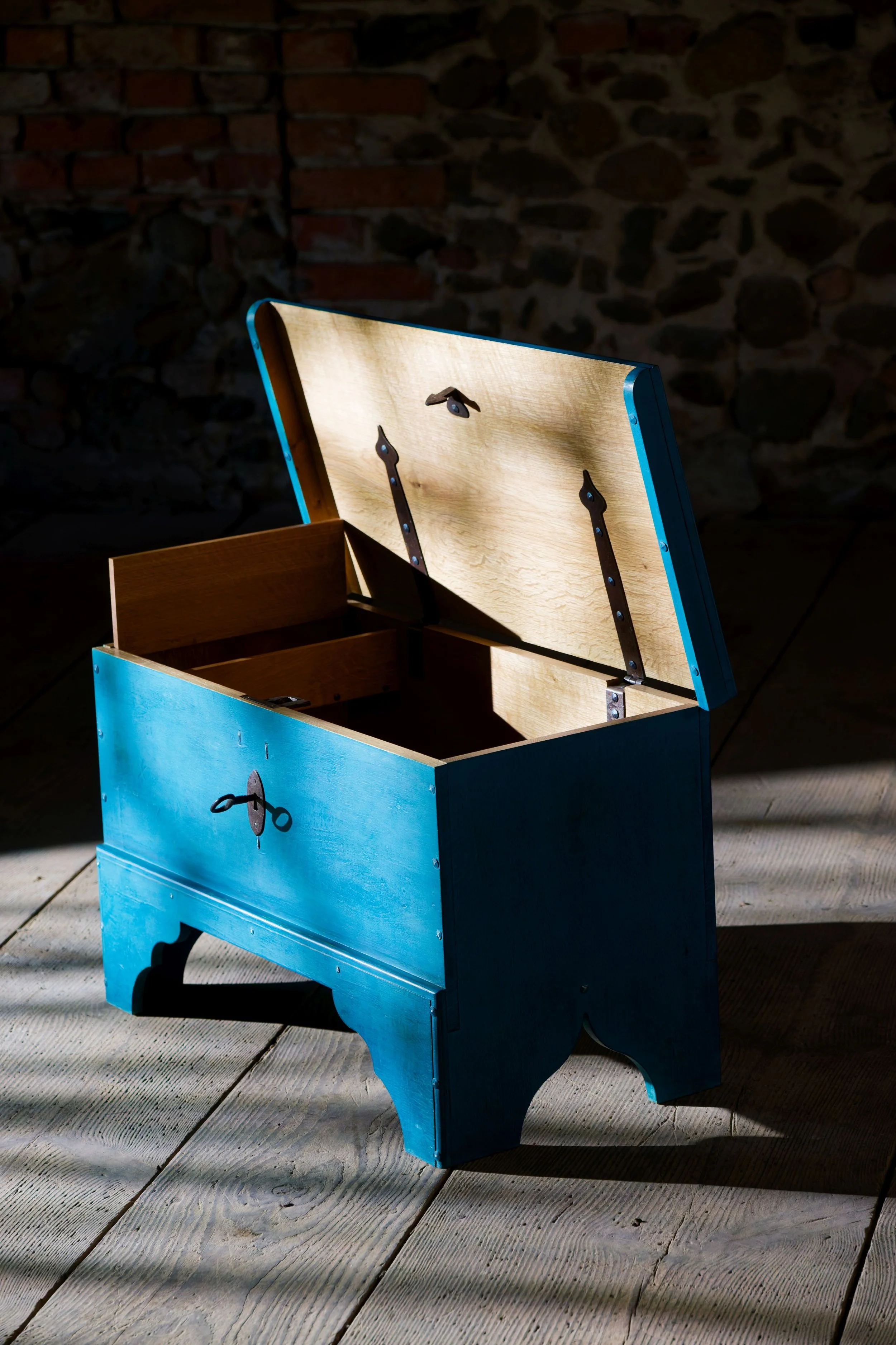 Blaue Truhe vor dunkelm Hintergrund 