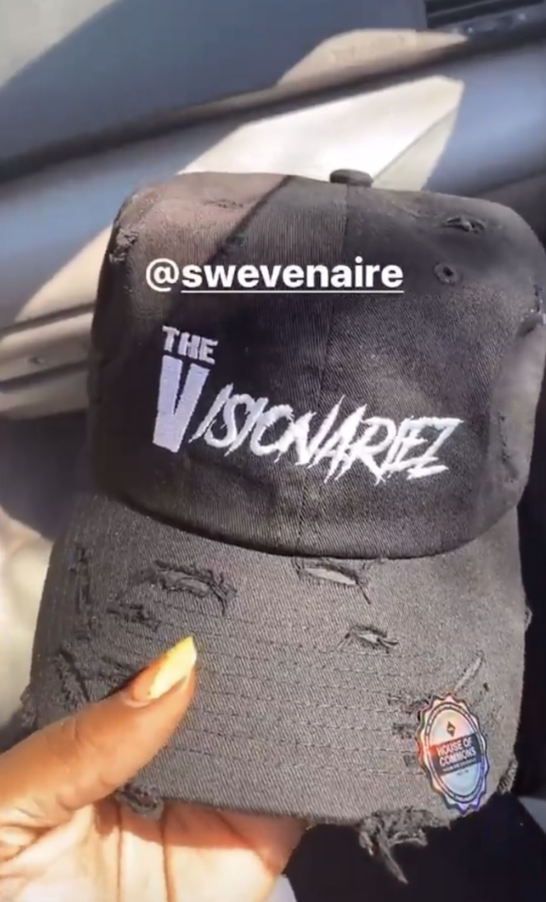 A black trucker hat with distressed details, featuring the text 'The Visionariez' and an Instagram handle '@swevenaire' embroidered on the front, with a sticker from the 'House of Commons' attached to the brim.