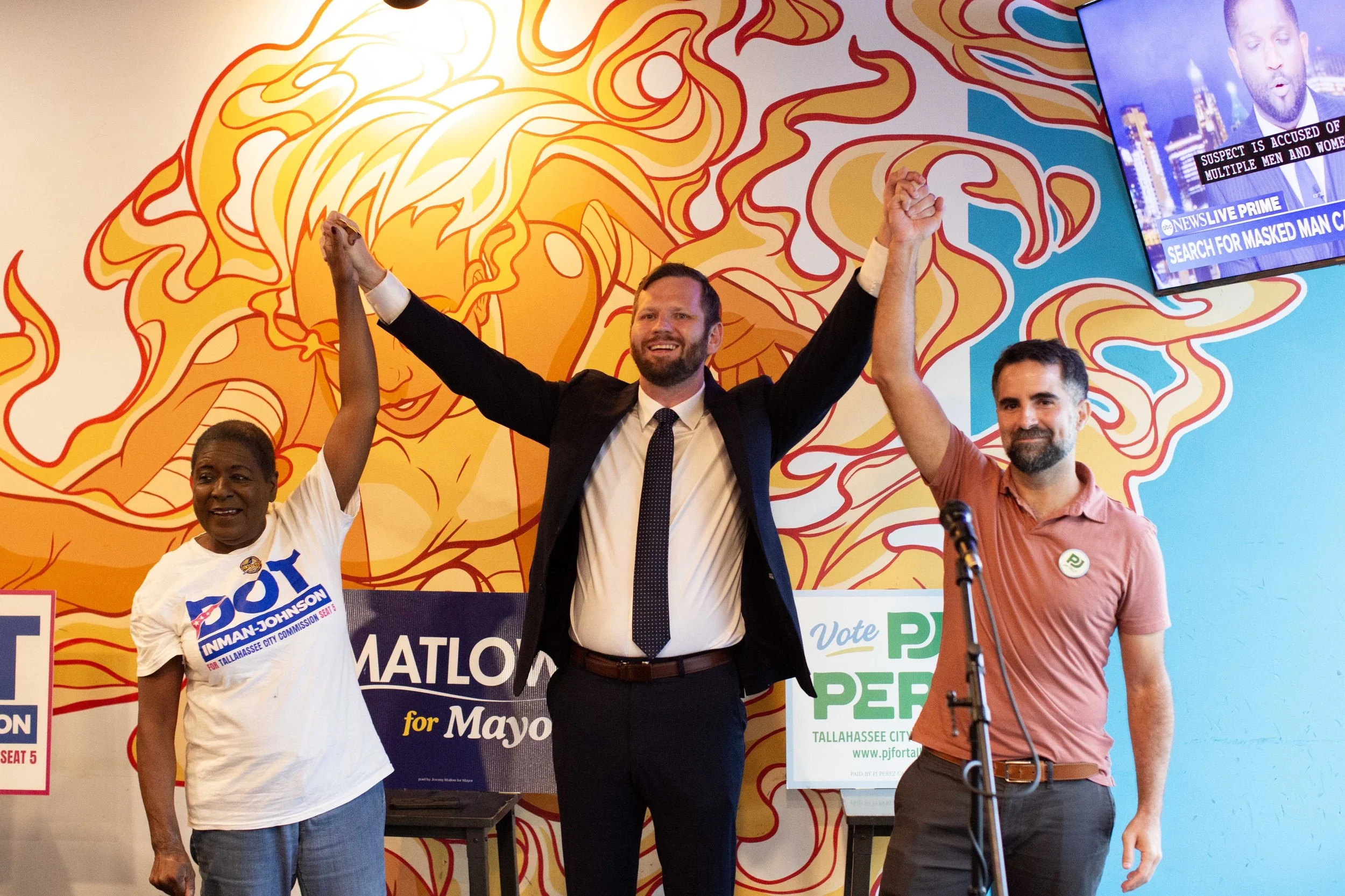 Dot Inman-Johnson, Jeremy Matlow, and PJ Perez join hands on election night at Gaines Street Pies in Tallahassee, Florida