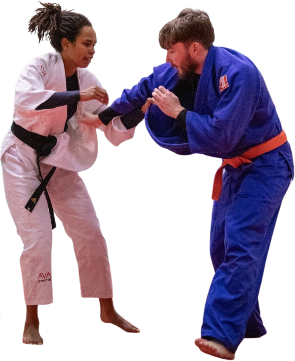 Two judo practitioners, a woman in a white gi with a black belt and a man in a blue gi with an orange belt, engaging in a match. The woman is grabbing the man's sleeve and collar while the man is gripping her collar and sleeve, both trying to gain an advantage.