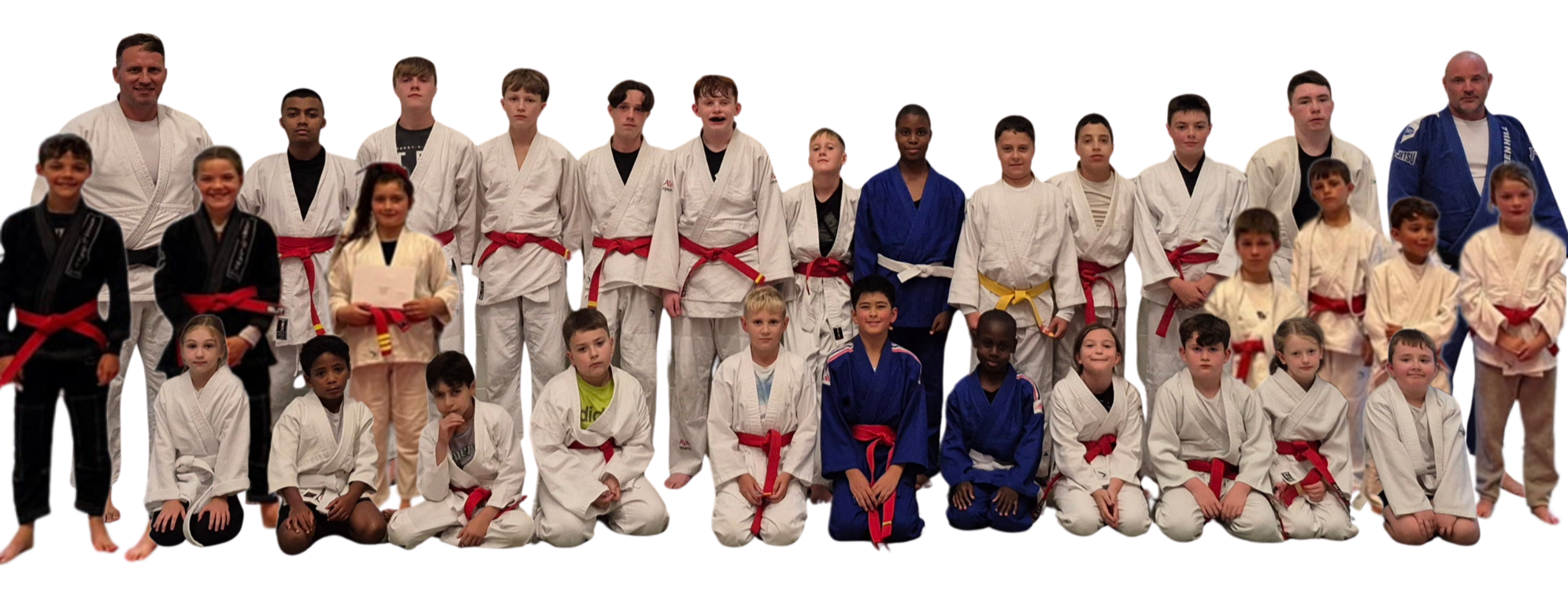 Group photo of children and adults in judo uniforms, some with red, blue, and black belts, on a dojo mat.