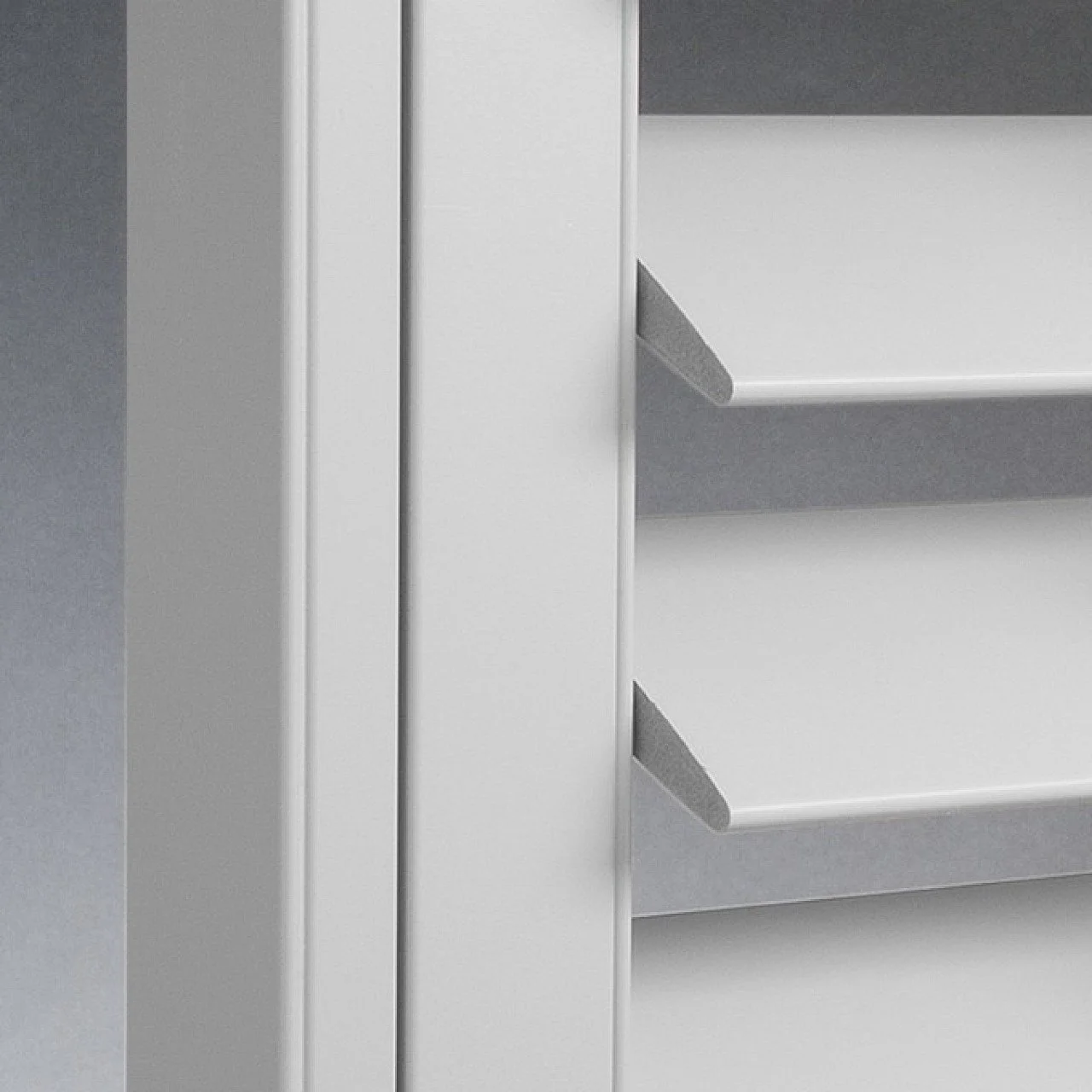 Close-up of a white cabinet with shelves, showing the side and part of the interior.