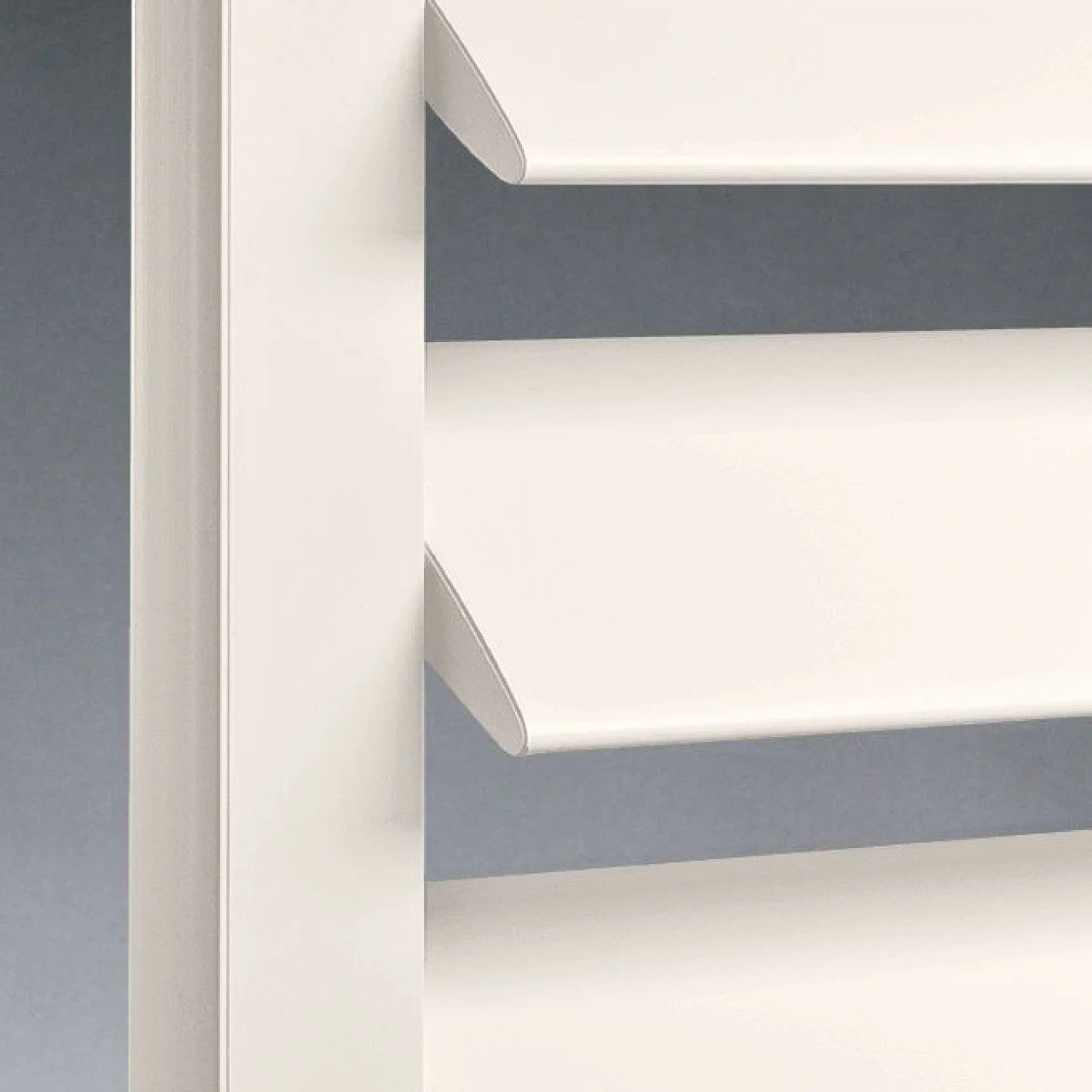 Close-up of white kitchen shelves mounted on a wall, with a white vertical panel on the left side.