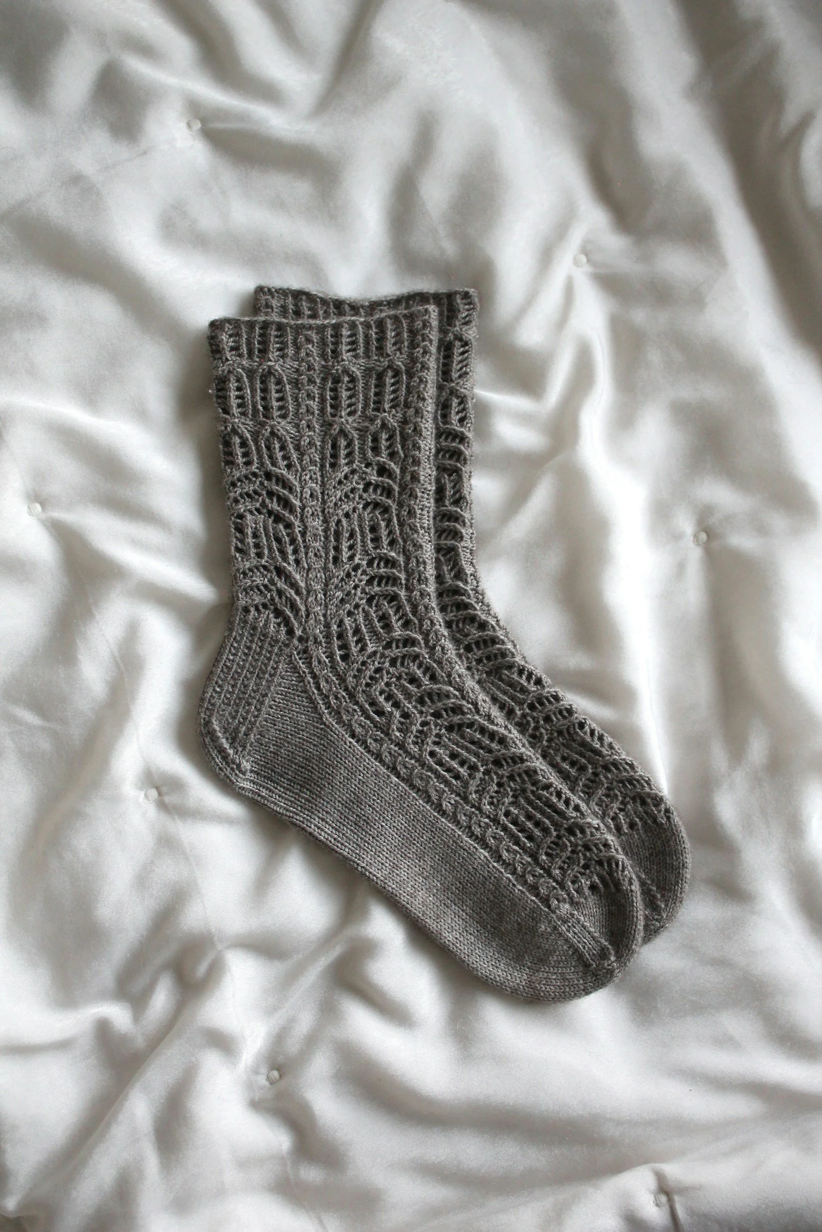 gray knit socks on white bedding