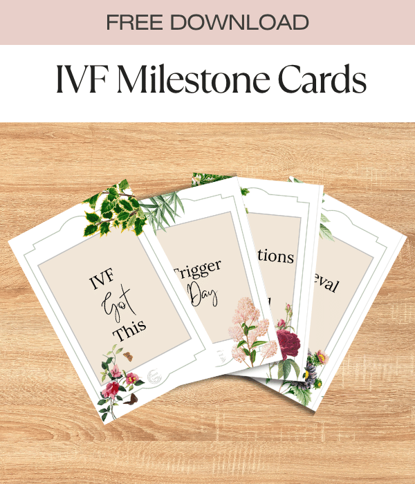 Set of IVF milestone cards with floral decorations and affirmations for fertility journey, shown on a wooden surface.