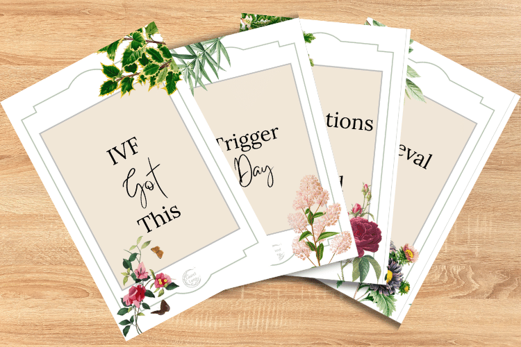A set of four wedding planning booklets with floral covers, titled 'IVF Got This,' 'Trigger Day,' 'Receptions,' and 'Reveals,' arranged on a wooden surface.