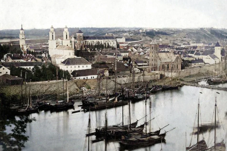 Colorized view of Kovno (Kaunas), Lithuania, in the mid 19th century with historic churches and sailing ships along the river.