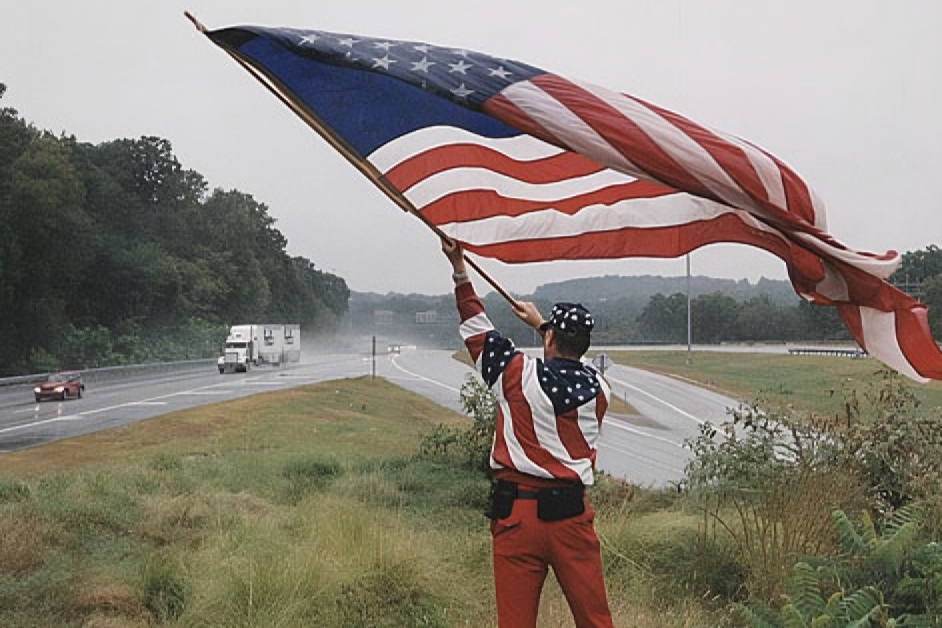 Brooks Breece waves the American flag on a hill overlooking I-95 on September 14, 2001.