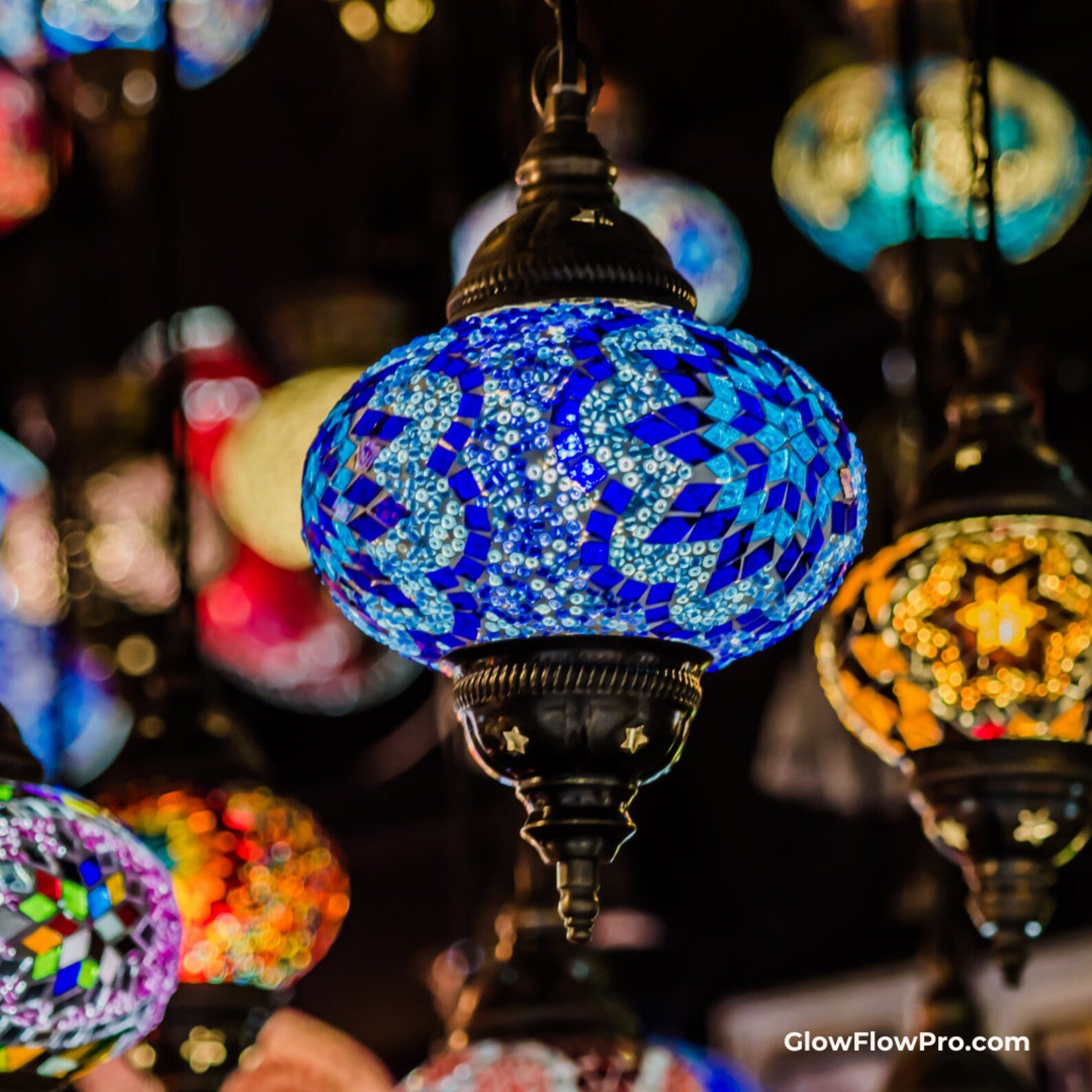 Colorful mosaic lamp glass Turkish lamp with blue, white, and other vibrant colors, hanging among other mosaic lamps.