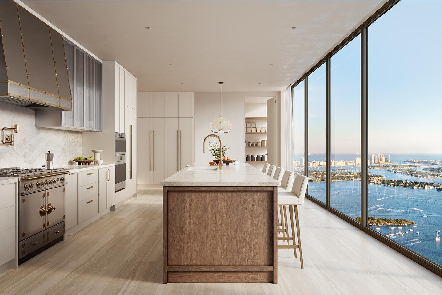 Modern kitchen with white cabinets, a marble island, overlooking a city and water through floor-to-ceiling windows.