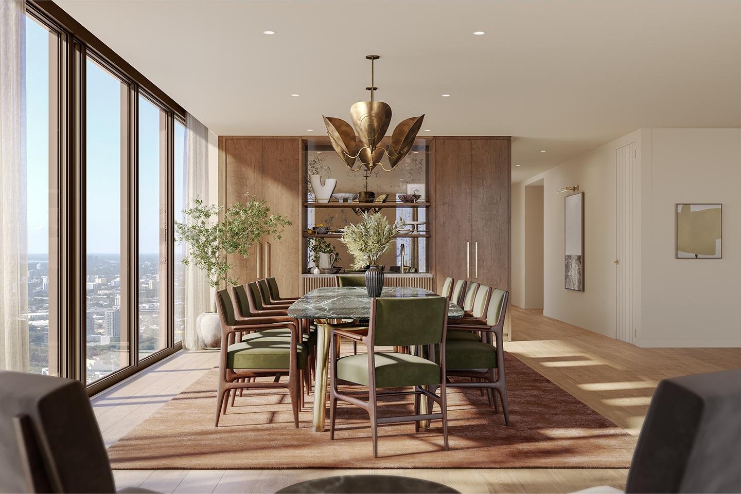 Modern dining room with a round marble table surrounded by green and wooden chairs, large windows with city view, a brass chandelier, and decorative shelves with vases and plants.