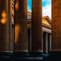 Close-up of classical architectural columns with ornate building facade in the background