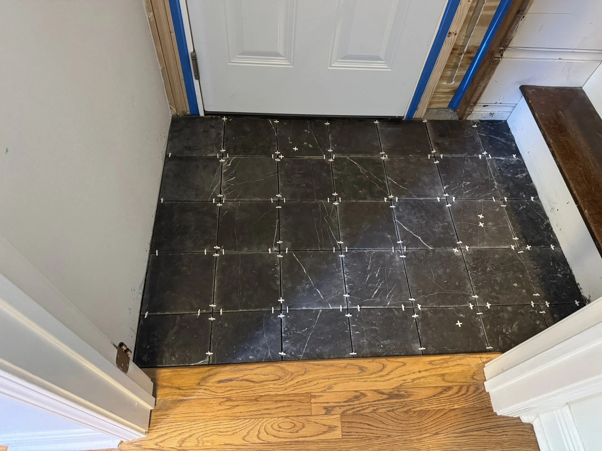 Avanelle Homes upgraded the door to the garage and laid new black marble tile in Alamo Heights, TX.