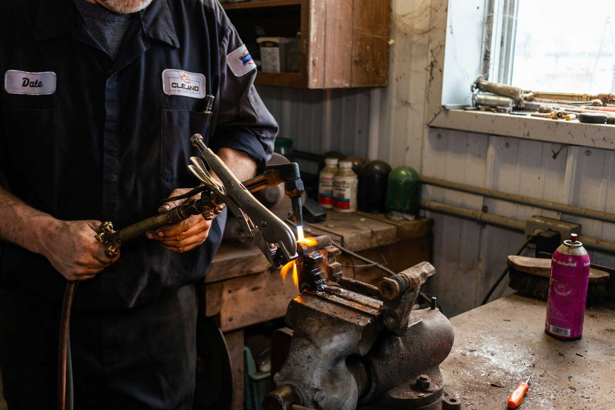 A technician is using a torch to braze together copper pipe.