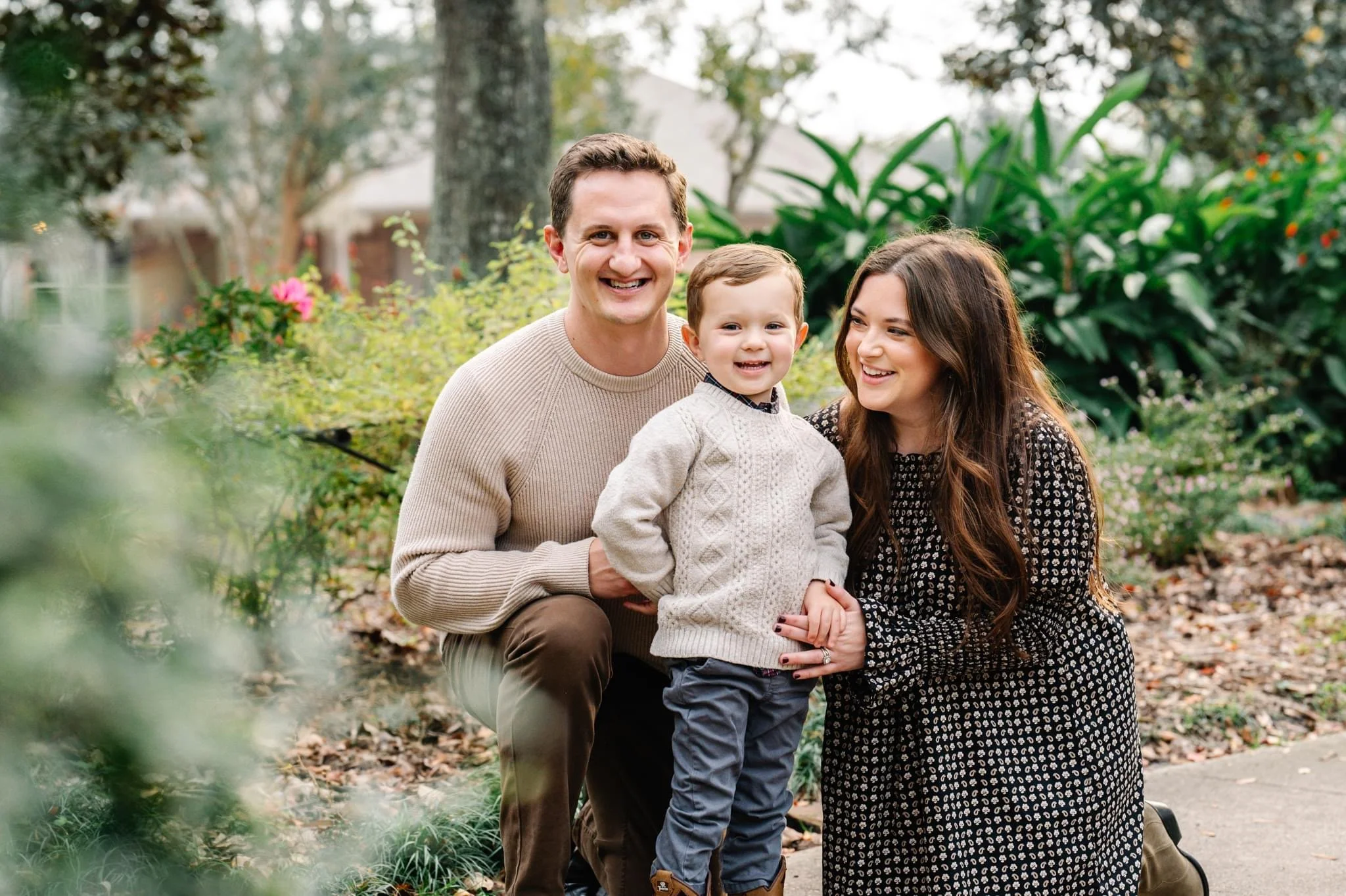 Michael and his family smile for a portrait in a garden with their son at a garden in Terrell Hills, TX.