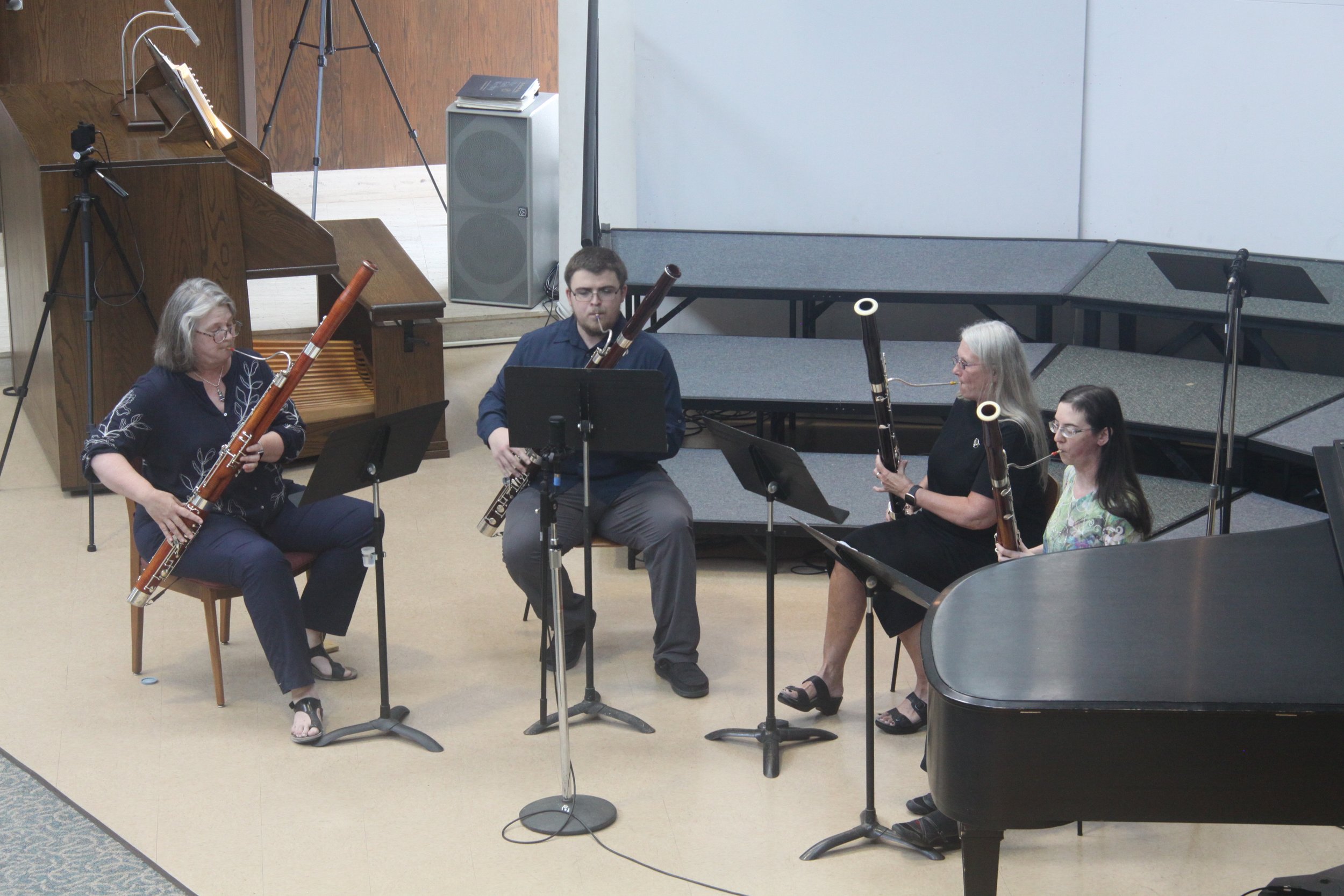 A group of four musicians seated on stage.