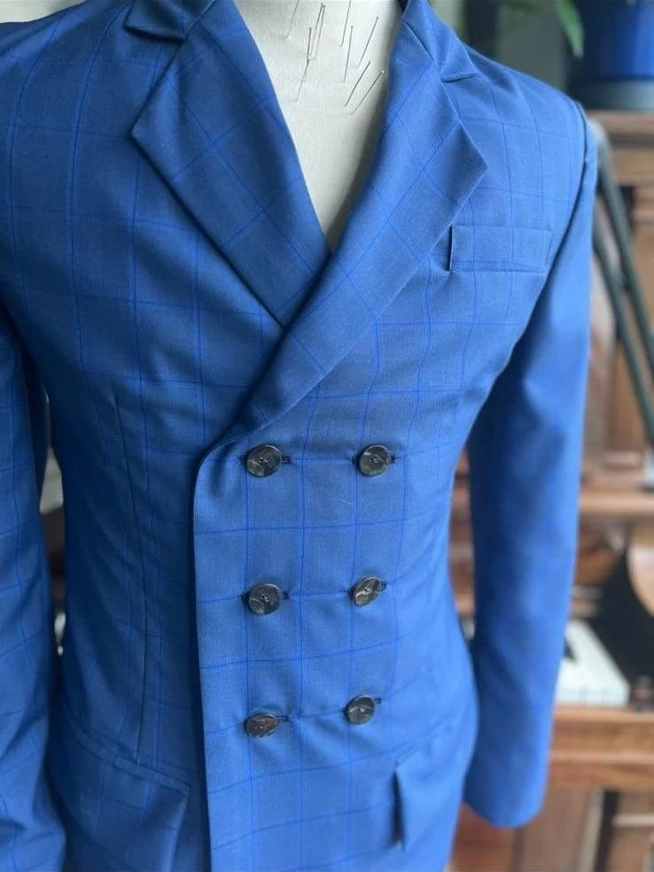 A blue checkered double-breasted blazer on a mannequin.