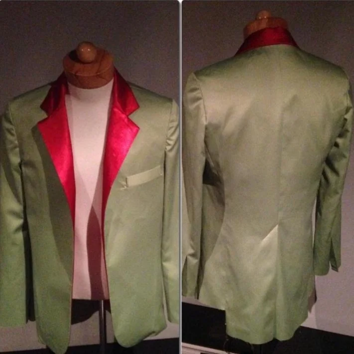 A mannequin wearing a light green tuxedo jacket with red satin lapel, seen front and back views.