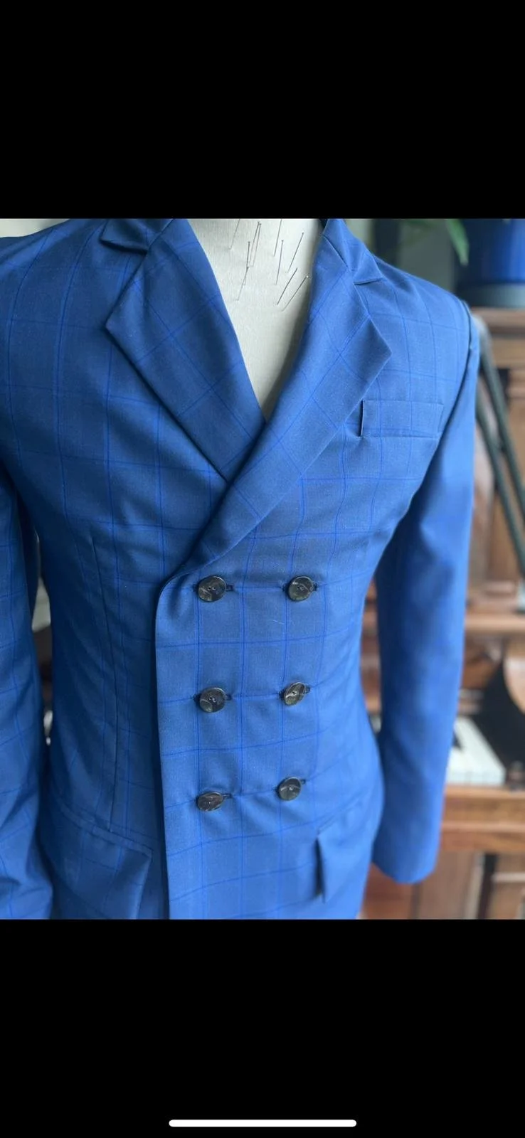 Blue plaid double-breasted suit jacket on a mannequin.