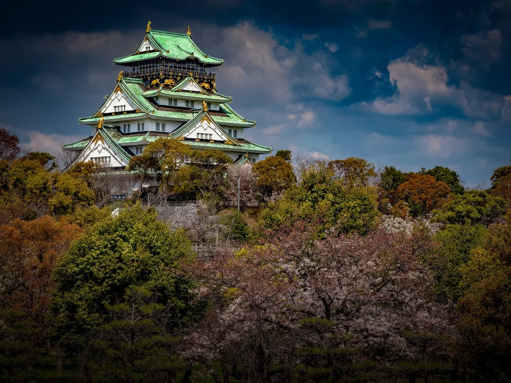 Osaka Castle rising above trees in Japan