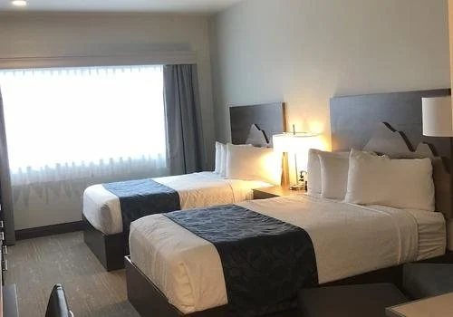 Modern hotel room with two queen beds at Compass Suites in Kodiak, Alaska — lodging near the working harbor before coastal bear adventures with World Untouched