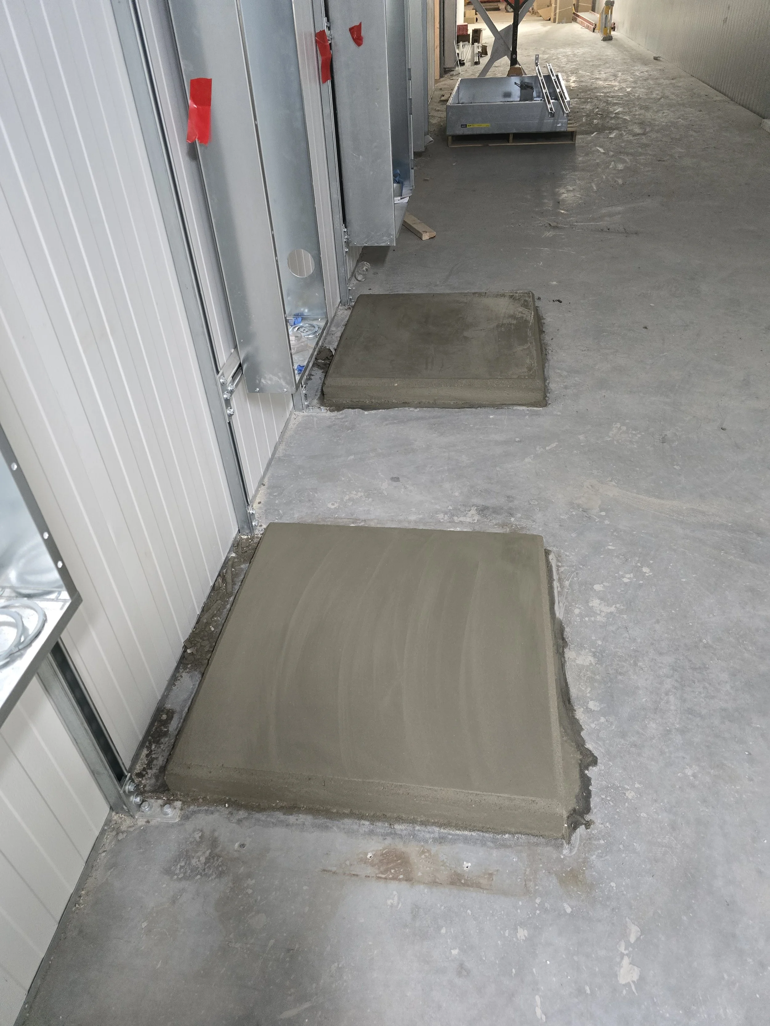 Concrete slabs in a construction area with building materials and tools around.