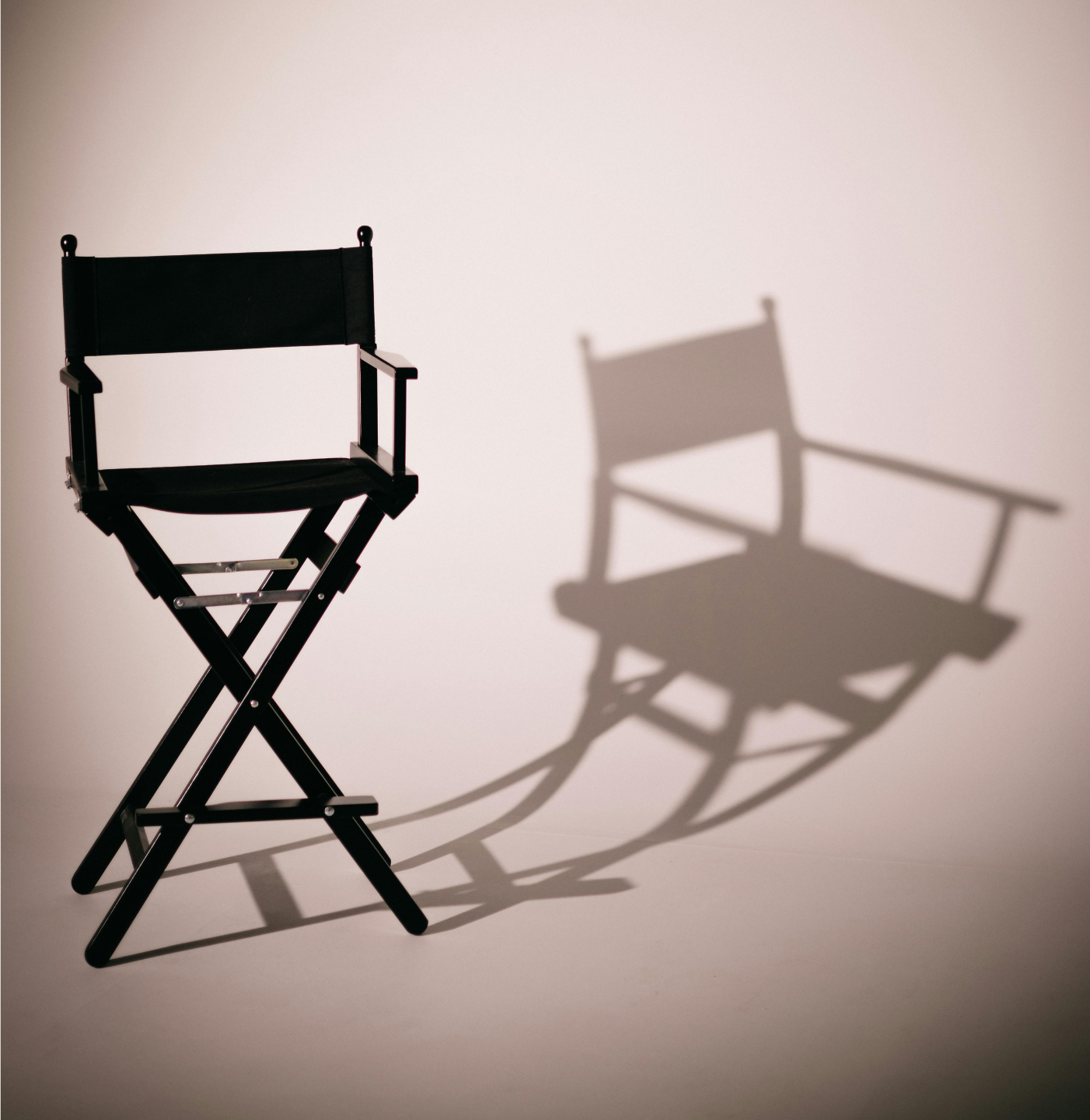 Empty directors chair with shadow on a neutral background