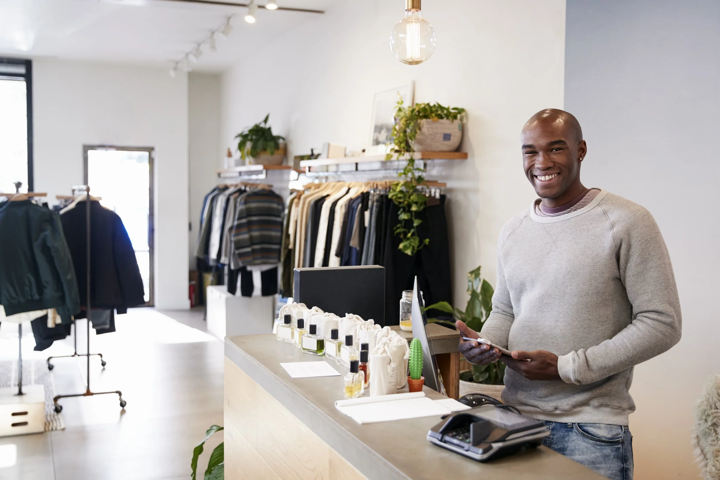 male-assistant-smiling-behind-the-counter-in-cloth-2024-10-19-16-47-38-utc.jpg