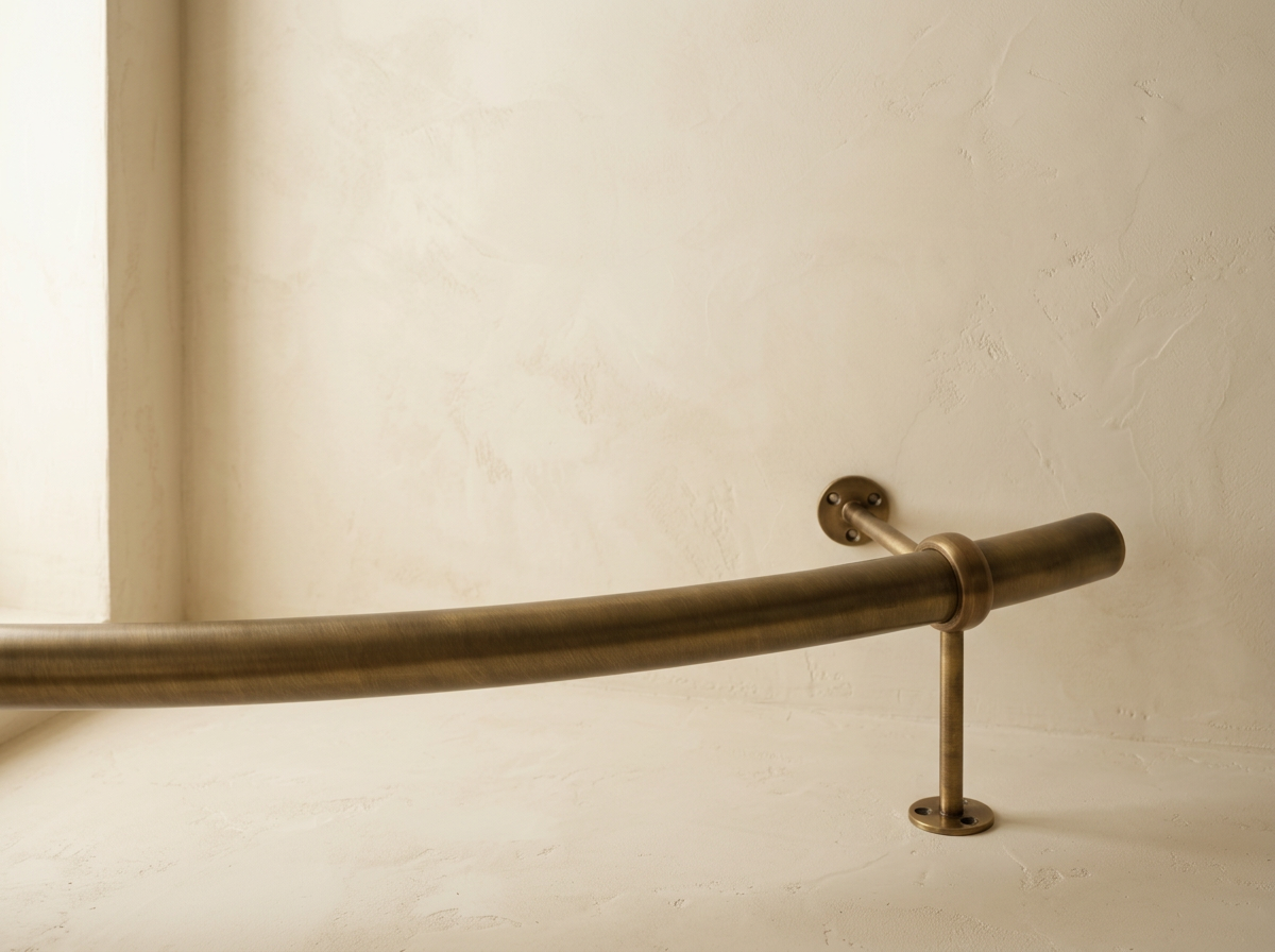 Brushed metal handrail attached to a beige wall with brackets.