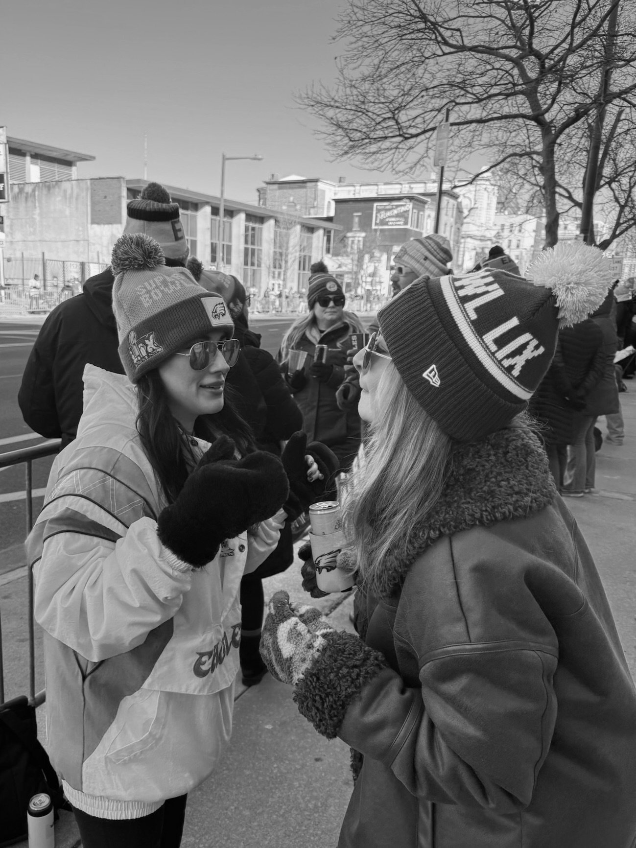 A black and white drawing of a woman with long hair, eyes closed, lips pursed, holding scissors near her hair.