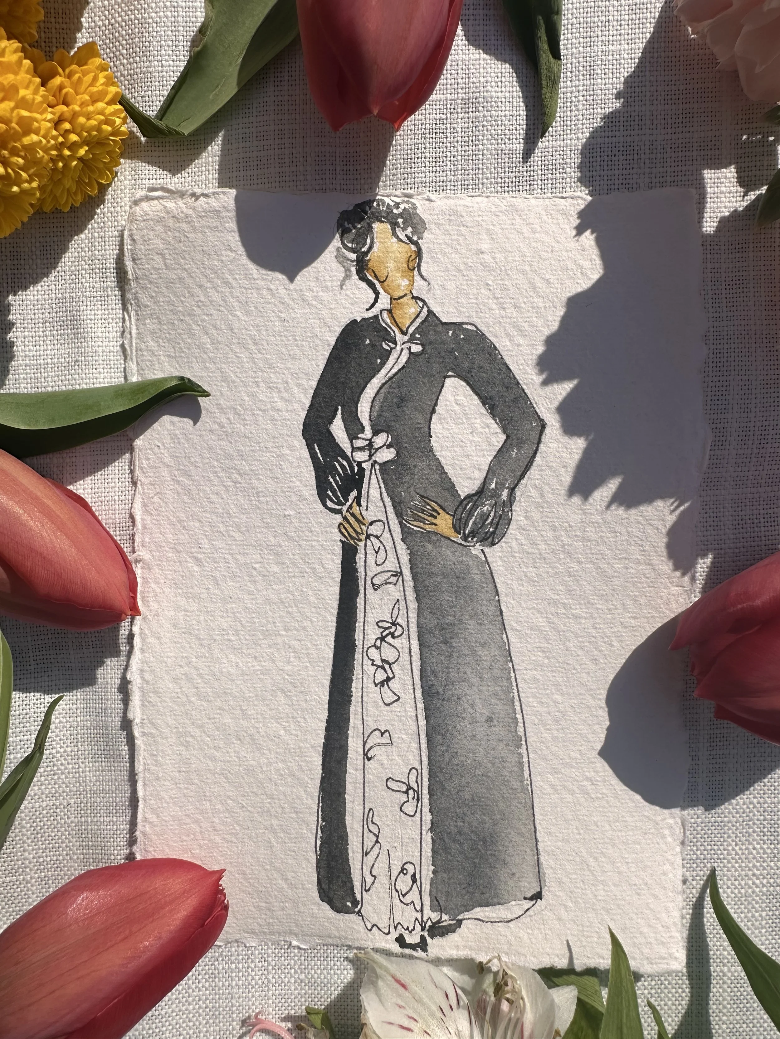 A watercolor illustration of a woman in a long black dress with a floral pattern, standing with her hand on her hip, surrounded by pink and white flowers.